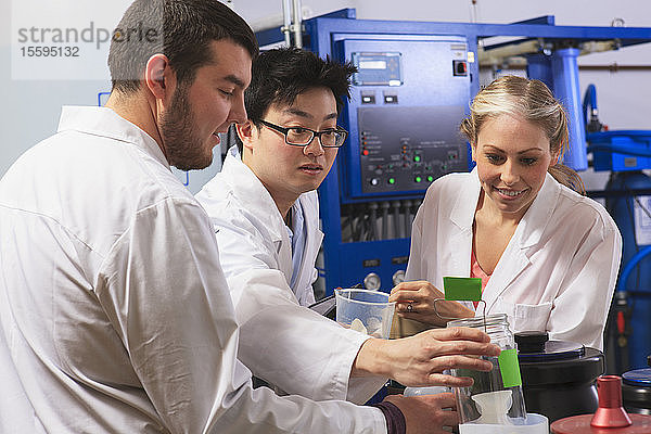 Ingenieurstudenten bei der Untersuchung von Flüssigkeitsbehältern im Raum für das Wasser-Ultra-Reinigungssystem in einem Labor