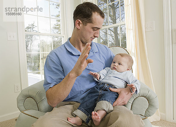Mann  der das Wort B in amerikanischer Zeichensprache gebärdet  während er mit seinem Sohn kommuniziert