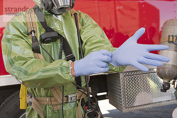 HazMat-Feuerwehrmann zieht Schutzhandschuhe an