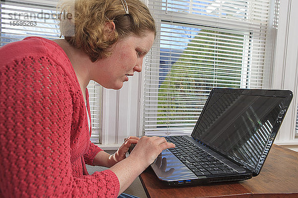 Junge Frau mit Autismus benutzt ihren Laptop