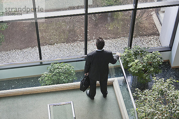 Geschäftsmann mit Aktentasche im Atrium eines Bürogebäudes