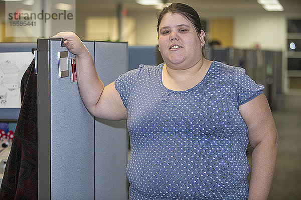 Porträt einer Frau mit einer Lernbehinderung  die in einem Büro arbeitet