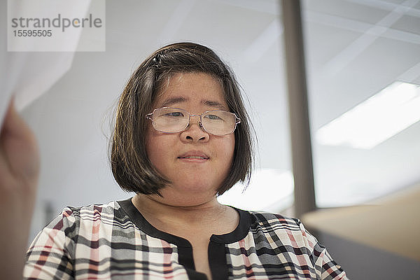 Asiatische Frau mit einer Lernbehinderung arbeitet an einem Kopiergerät