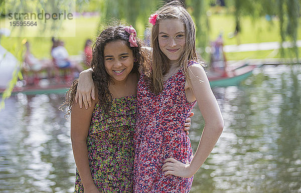 Porträt von zwei hispanischen Teenager-Schwestern  die zusammen in einem Park posieren
