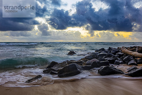 Sonnenaufgang durch die Wolken über dem Pazifik  gesehen vom Lydgate Strand; Kapaa  Kauai  Hawaii  Vereinigte Staaten von Amerika