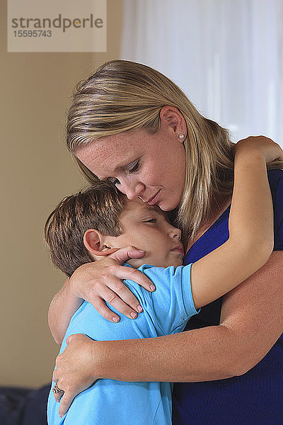 Mutter und Sohn mit Hörbehinderung umarmen sich