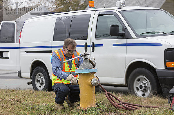 Techniker des Wasserwirtschaftsamtes bringt Kappen auf Hydranten an