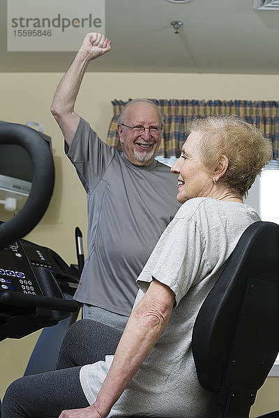 Ein älteres Paar trainiert im Fitnessstudio.