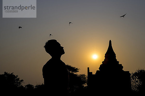 Silhouetten eines Mannes und eines buddhistischen Tempels; Bagan  Region Mandalay  Myanmar