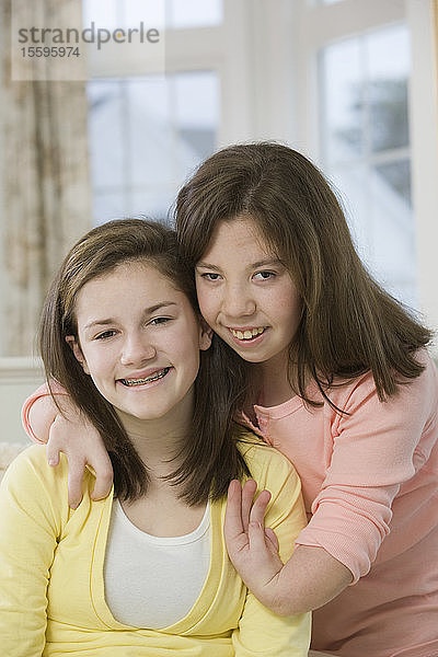 Zwei lächelnde Mädchen im Teenageralter  eines mit Geburtsfehler