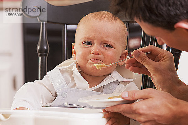 Vater füttert seinen Sohn  der sich weigert  zu essen