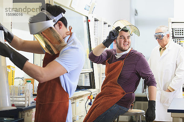 Ingenieurstudenten und Professor tragen Schutzausrüstung bei der Arbeit im Chemielabor