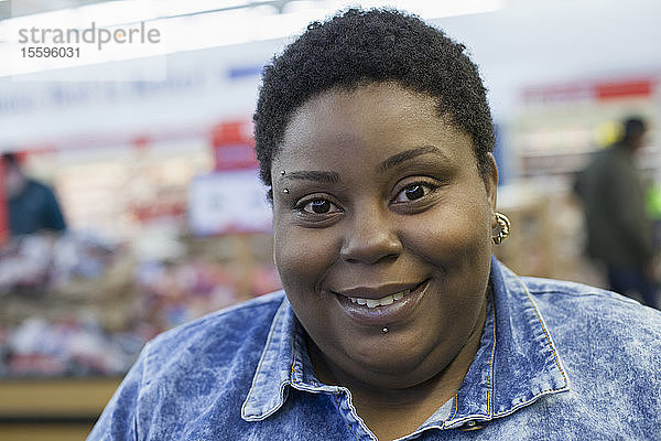 Porträt einer glücklichen Frau mit bipolarer Störung beim Einkaufen in einem Supermarkt