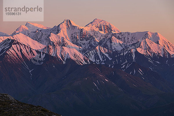 Alpenglühen bei Sonnenaufgang in der Eastern Alaska Range  einschließlich (von links nach rechts) Mount Shand  McGinnis Peak und Mount Moffit; Alaska  Vereinigte Staaten von Amerika