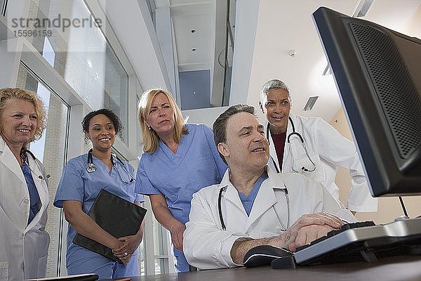 Ärzte und Krankenschwestern beraten sich an einem Computer im Krankenhaus