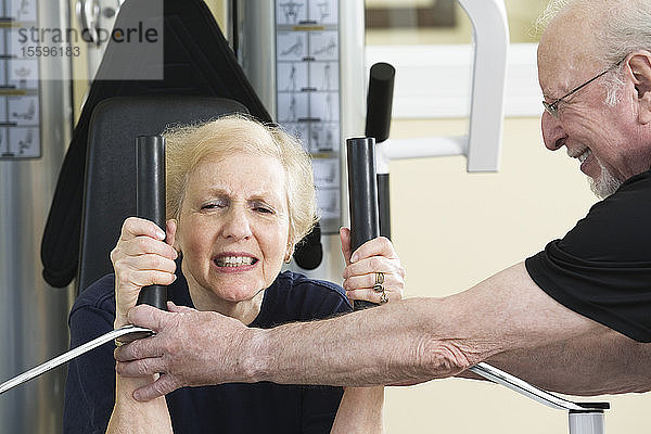 Ein älteres Paar trainiert im Fitnessstudio.