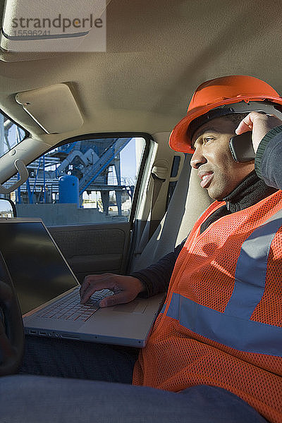 Ingenieur bei der Arbeit an einem Laptop in einem Auto