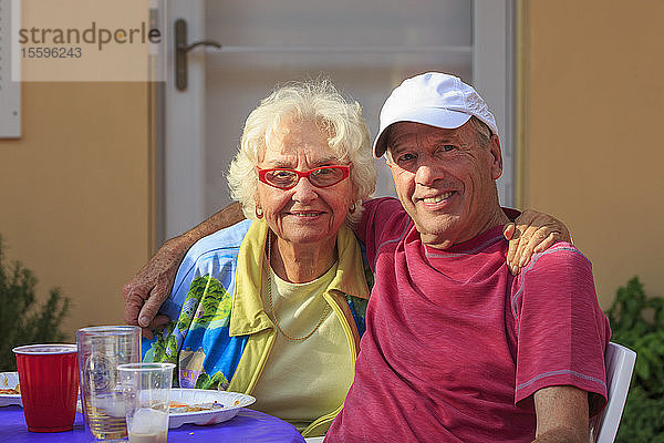 Porträt eines älteren Paares beim Abendessen im Freien