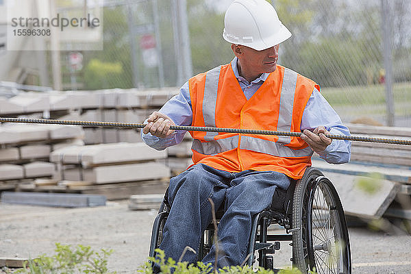 Projektingenieur mit einer Rückenmarksverletzung in einem Rollstuhl auf der Baustelle