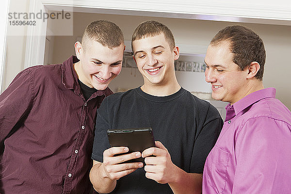 Drei Brüder lesen eine digitale Tafel
