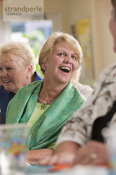 Lachende Seniorinnen bei einem Mittagessen