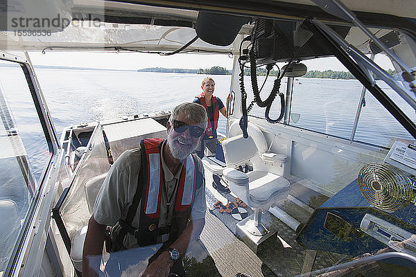 Zwei Ingenieure auf einem Serviceboot bereiten sich auf die Entnahme von Wasserproben aus der öffentlichen Wasserversorgung vor