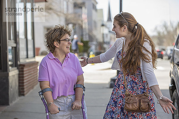 Frau mit zerebraler Lähmung geht mit ihrer Schwester in der Stadt spazieren