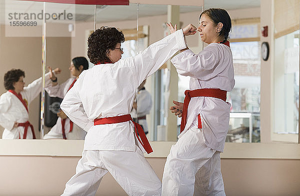 Junge Frau übt Karate mit einer mittelalten Frau