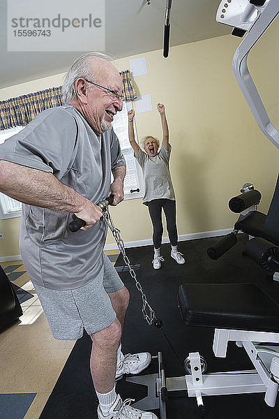 Ein älteres Paar trainiert im Fitnessstudio.