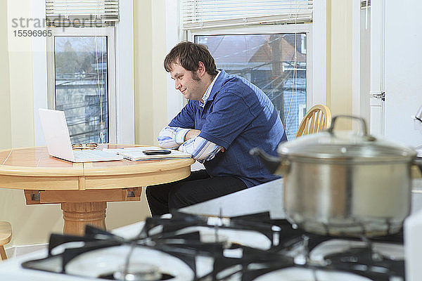 Mann mit Asperger-Syndrom arbeitet beim Kochen in seinem Haus