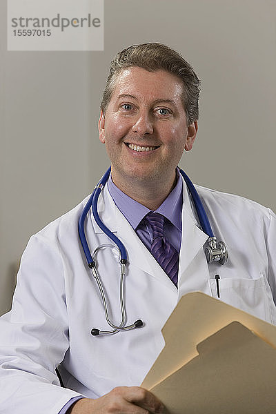 Arzt sitzt in seinem Büro und lächelt