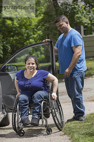 Frau mit Spina Bifida und ihr Mann beim Aussteigen aus dem Auto