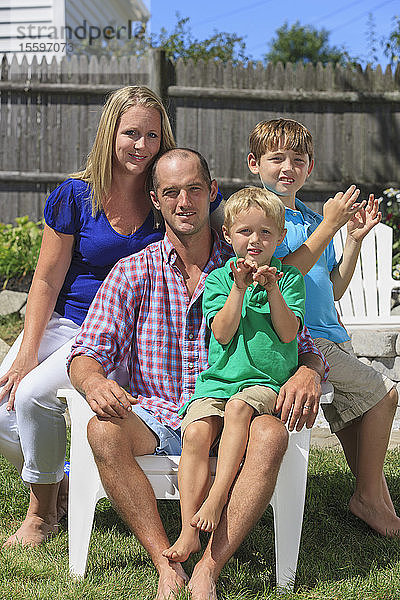 Porträt einer glücklichen Familie mit Hörbehinderung  die Familie in amerikanischer Zeichensprache gebärdet