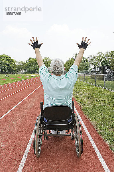 Mann mit Muskeldystrophie in einem Rollstuhl auf einer Rennstrecke