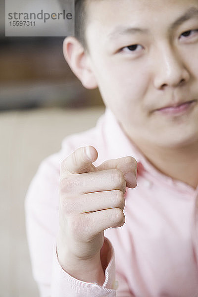 Porträt eines Teenagers  der mit dem Finger zeigt