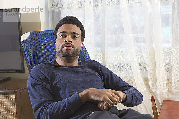 Porträt eines afroamerikanischen Mannes mit zerebraler Lähmung zu Hause