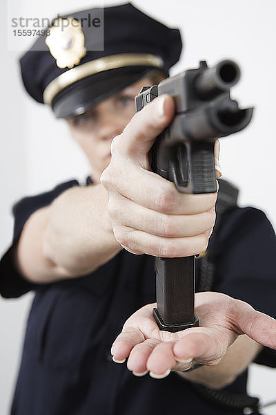 Eine Polizistin lädt eine Pistole.