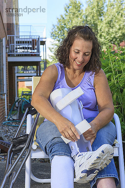 Frau mit Spina bifida passt Beinschiene an  damit sie gehen kann