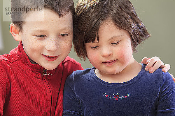 Kleines Mädchen mit Down-Syndrom mit ihrem Bruder