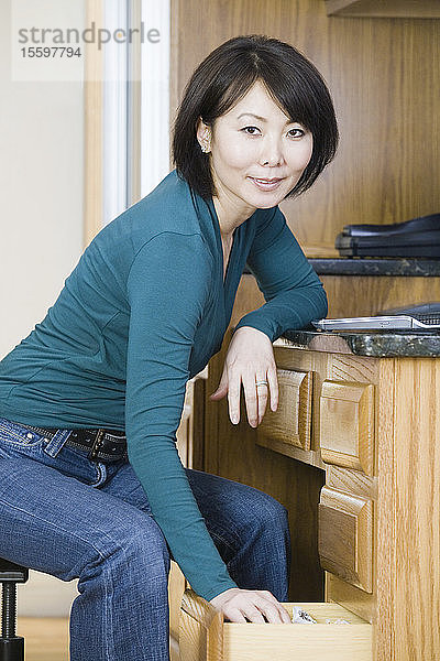 Porträt einer mittleren erwachsenen Frau  die in der Küche lächelt