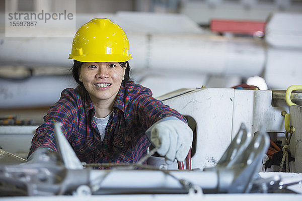 Weiblicher Energietechniker packt Werkzeuge in einen Kübelwagen