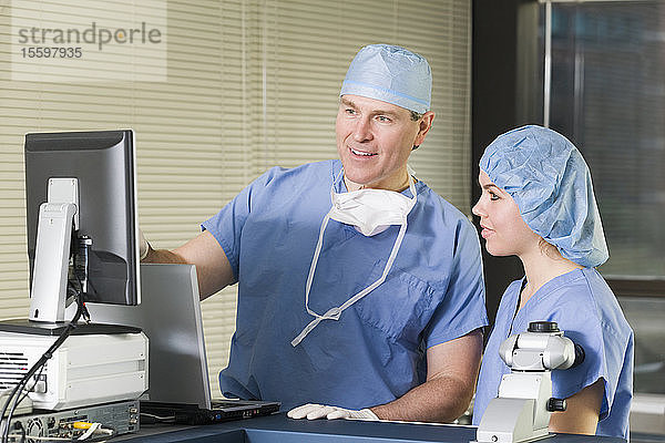 Zwei Chirurgen bei der Arbeit an einem Lasergerät