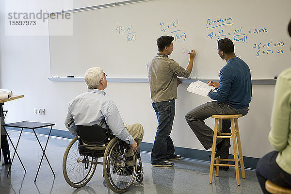 Universitätsprofessor mit Muskeldystrophie mit seinen Studenten in einem Klassenzimmer