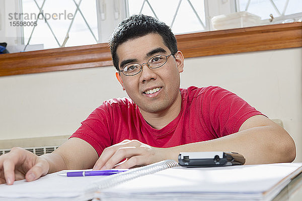 Porträt eines asiatischen Mannes mit Autismus bei der Arbeit in seinem Haus