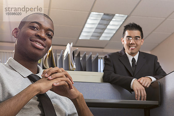 Porträt von zwei lächelnden Männern mit Autismus in einem Büro