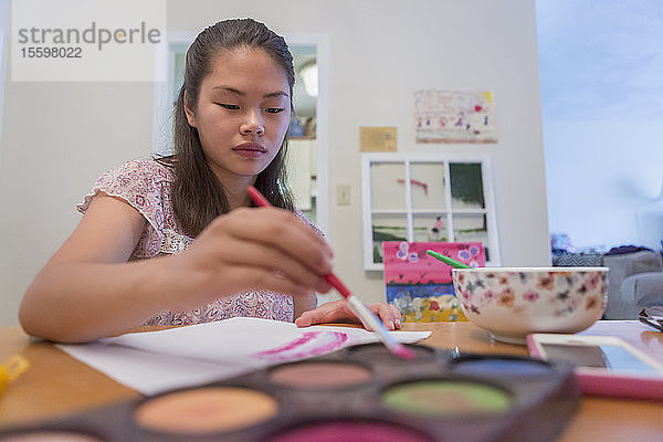 Teenager-Mädchen mit einer Lernbehinderung verwendet Farben