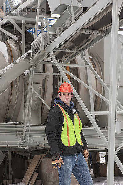 Ingenieur in einer Industrieanlage vor einem Trommeltrockner stehend