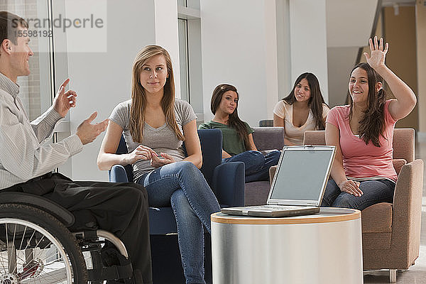 Lehrer mit Rückenmarksverletzungen hält einen Vortrag vor Schülern im Klassenzimmer