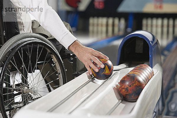 Mittelteilansicht eines Mannes mit einer Rückenmarksverletzung beim Bowling