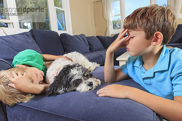 Hörgeschädigte Jungen gebärden Schlaf in amerikanischer Zeichensprache auf ihrer Couch